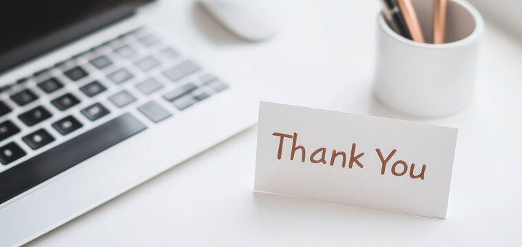 Thank you card on minimalist workspace with laptop and stationery