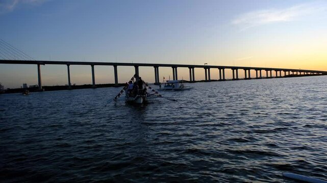 Boats on the water near a long bridge during sunset in the Philippines, capturing maritime culture, travel vibes, and serene landscapes perfect for stock footage.