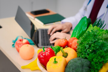 A male nutritionist sitting at a table, advising on healthy diets, promoting vegetable-based meals,...