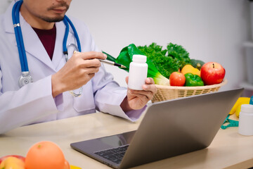 A male nutritionist sitting at a table, advising on healthy diets, promoting vegetable-based meals,...