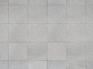 Top view of classic light grey ceramic porcelain tiles for interior floor. Textured gray square...