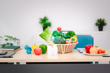 A nutritionist's table with a vegetable basket, fruits, pill bottles, and a dumbbell, symbolizing...