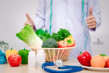 A male nutritionist sitting at a table, advising on healthy diets, promoting vegetable-based meals,...