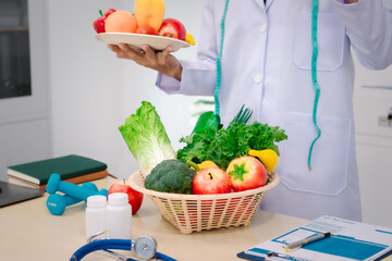 A male nutritionist sitting at a table, advising on healthy diets, promoting vegetable-based meals,...