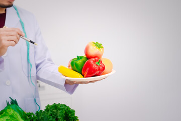 A male nutritionist sitting at a table, advising on healthy diets, promoting vegetable-based meals, supplements, weight loss, and meal planning to improve overall health and well-being
