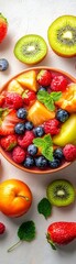 Obraz premium Fresh Fruit Salad in a Bowl with Kiwi and Mint