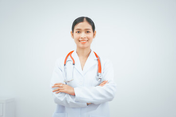 Fototapeta premium A young female doctor expert, smiling in a white coat with a stethoscope, stands against a white background, holding a medical report, providing online advice in a doctor's office