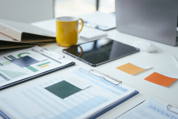 Fototapeta premium An office desk with a computer, documents, and graphs represents a workspace for professionals analyzing data, managing reports,making strategic decisions in business, finance, or administration