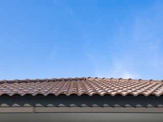 Naklejka premium The top of the house&nbsp;roof shows the ceiling and fiber cement roof tiles with a blue sky in the background.
