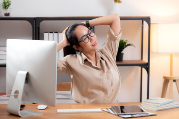 Portrait young asian businesswoman wearing glasses taking a break after overworked with stretching...