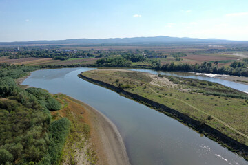 Obraz premium Flying over a river flowing on a plain aerial view