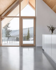 Modern minimalist interior with large windows showcasing snowy mountain landscape
