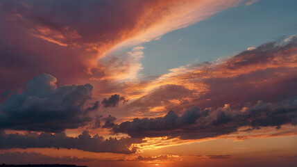 Fototapeta premium a dramatic sunset sky with vibrant colors. The clouds are a mixture of deep purple, fiery orange and bright pink, with the sun breaking through the clouds. The sky is a canvas of rich colors.