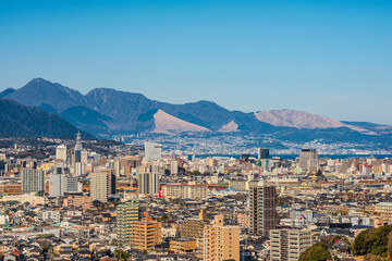 大分市市街地と遠くに見える鶴見岳の風景