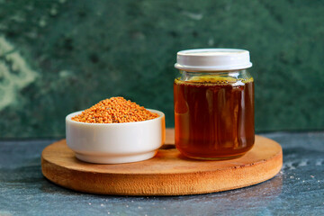 A bowl of Mustard seeds and a jar of Mustard oil  on a table