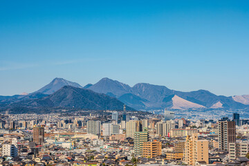 大分市市街地と遠くに見える鶴見岳と由布岳の風景