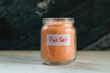 Pink salt in a glass jar with a label on it