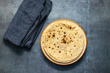 Roti is a traditional, round, unleavened flatbread made from whole wheat flour, commonly served with curries or vegetables.