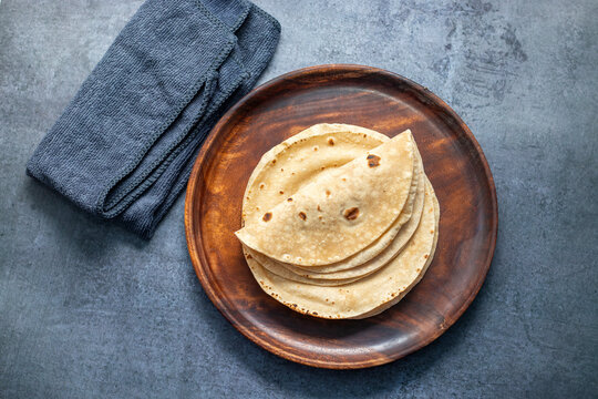 Roti is a traditional, round, unleavened flatbread made from whole wheat flour, commonly served with curries or vegetables.