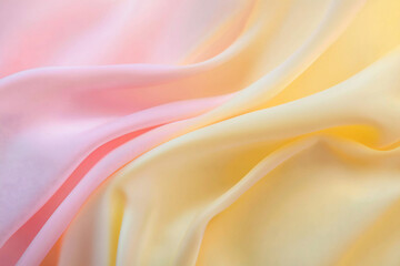 Obraz premium Soft pastel fabric draping elegantly, blending pink and yellow hues, ideal for fashion and design