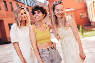 Three young beautiful smiling hipster female in trendy summer stylish clothes. Sexy carefree women posing in the street. Positive models having fun, hugging and going crazy, in sunny day