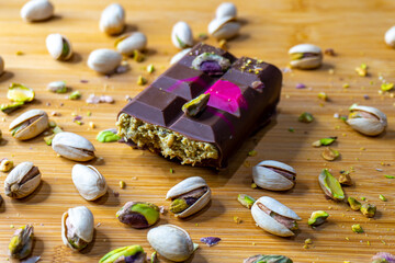 Dubai Chocolate bar with green kadayif and pistachio spread with pistachio nuts close up