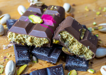 Dubai Chocolate bar with green kadayif and pistachio spread with pistachio nuts close up