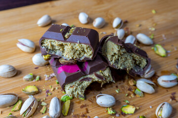 Dubai Chocolate bar with green kadayif and pistachio spread with pistachio nuts close up