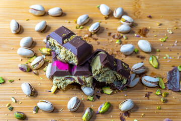 Dubai Chocolate bar with green kadayif and pistachio spread with pistachio nuts close up