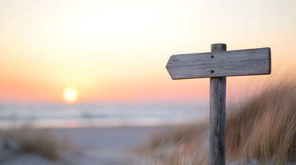 A weathered wooden signpost stands near the dunes, its empty directional planks pointing aimlessly. Behind it, the sun sinks into the horizon, casting golden reflections on the rippling ocean