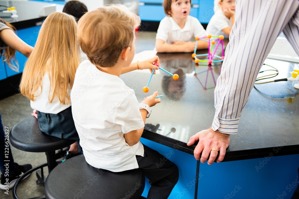Poster Children in a science class, sitting at a table, engaged in a hands-on activity with colorful models. Teacher nearby, guiding the science lesson. Science teacher teaching school kids.