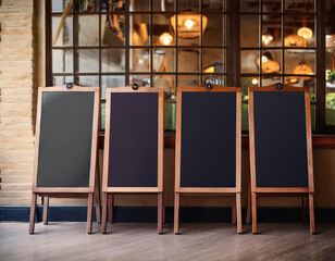 Four blank menu boards hang in a cafe. Perfect for showcasing restaurant menus or promotions 