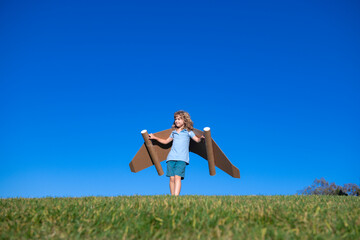 Kid boy playing with jetpack outdoor. Child with cardboard wings. Spring travel and adventure. Kids success and leader, startup concept. © Volodymyr