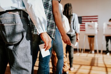 Diverse people in line voting in election, holding ballots. Voting in election, diverse group of people casting ballots. Diverse people voting, US election, close up photo of hand holding ballots