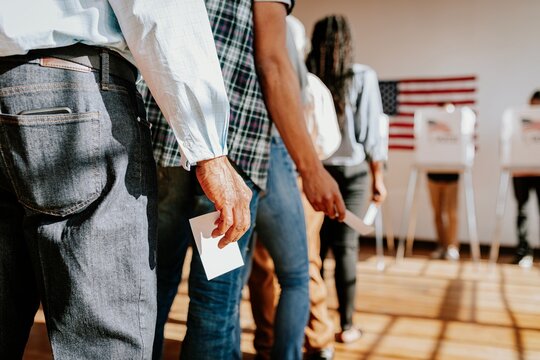Diverse people in line voting in election, holding ballots. Voting in election, diverse group of people casting ballots. Diverse people voting, US election, close up photo of hand holding ballots