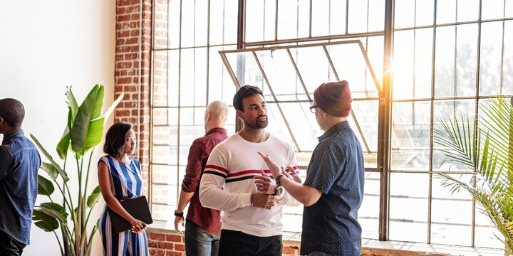 Diverse group of people in casual modern office, discuss ideas. Diverse men and women team in office, casual social meeting. Group of diverse team in modern office meeting, socialize and share ideas