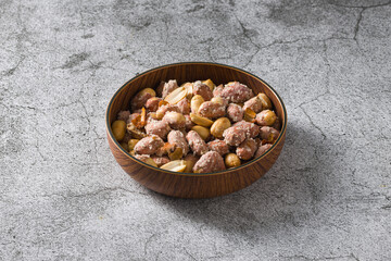 Top view of salted peanuts in wooden bowl