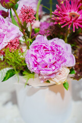 Beautiful bouquet of pink flowers in a white vase on the table. bouquets of fresh flowers in the interior.