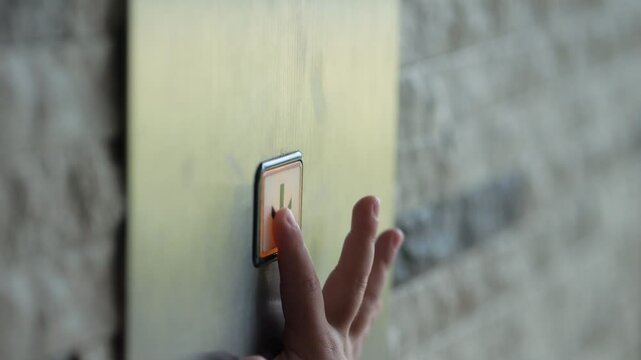 Child hand presses on button with arrow in modern lift