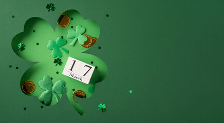 Green paper four-leaf clover with a date reminder for March 17, representing Irish festive...