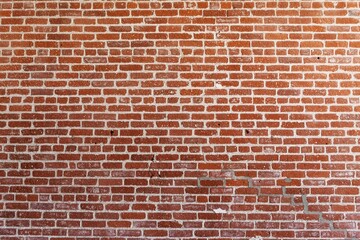 Red brick wall with uniform pattern background. Brick texture, brick color, and brick layout create a classic brick wall appearance background. Solid brick structure. Rustic brick wall background.