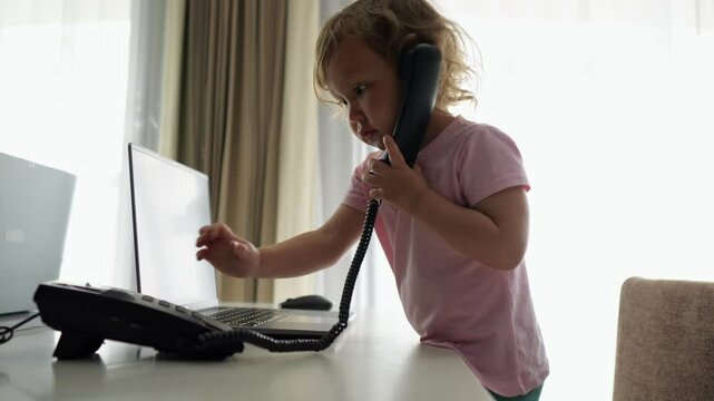 Preschooler girl picks up landline phone and pretends to talk