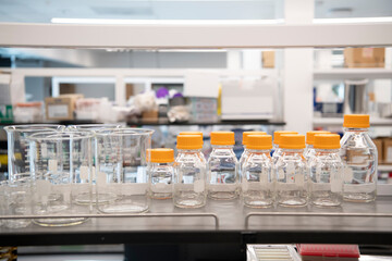 various clear glass jars and beakers on science lab shelf