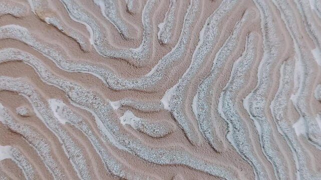 A winding line pattern with a rough texture in cream and white, resembling a natural pattern on sand or the ground surface. At the bottom, there is a media player control screen. Texture illustration