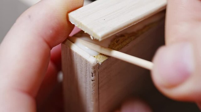 the master glues the veneer edge, thin natural wood, came off the furniture. wear and tear of old furniture.