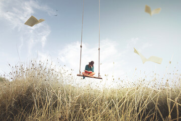 woman on a swing suspended in the sky reads a book, surrounded by flying pages that look like birds