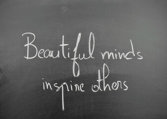 Obraz premium Beautiful minds inspire others written on a chalkboard with elegant handwriting