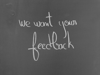 Obraz premium We want your feedback written on a chalkboard surface in white chalk script