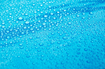 Side view of droplets with blue color background suitable for wallpaper
