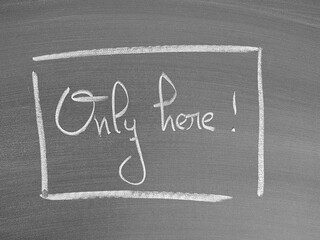 Fototapeta premium Only here message written on a chalkboard in handwritten script